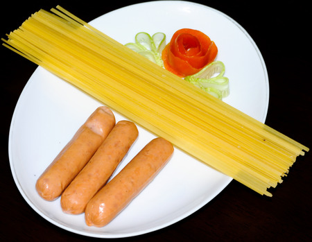 Uncooked spaghetti implant sausage ready cookの写真素材
