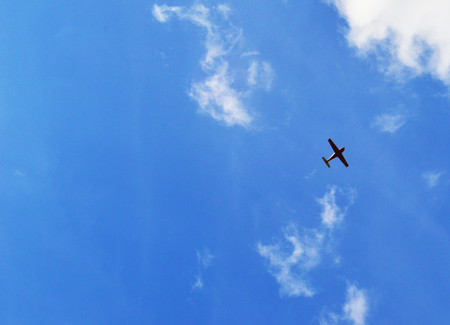 A small plane high in the sky. The view from the groundの写真素材
