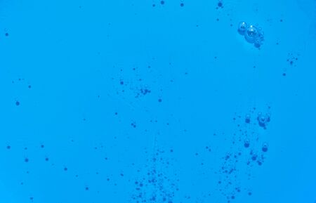 Bright blue texture transparent liquid with bubbles. Bright blue water with bubbles. Closeupの写真素材