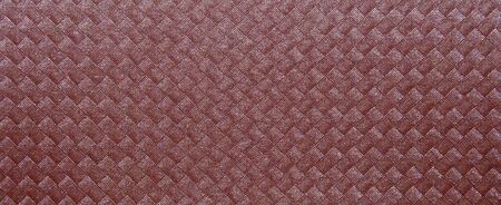 Red texture with a woven pattern of squares with stripes. Closeup