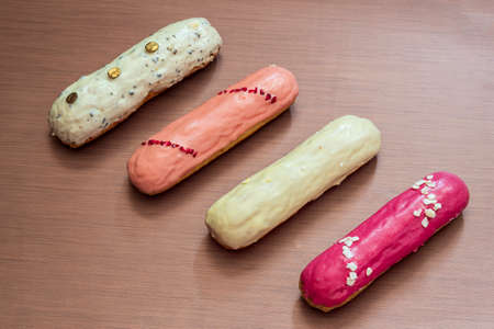 Four eclairs isolated on the brown background