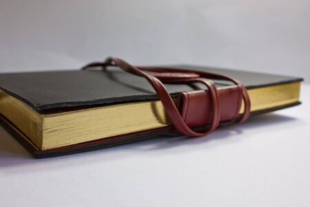 A black leather notebook against a white backgroundの写真素材