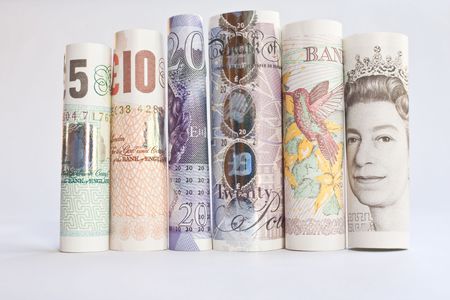 A pile of rolled British Banknotes against a white backgroundの写真素材