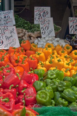 Peppers and vegetables displayed on a market stallの写真素材