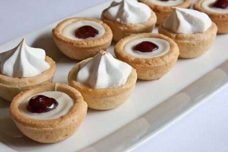 A plate of mini bakewell tarts and lemon meringue piesの写真素材