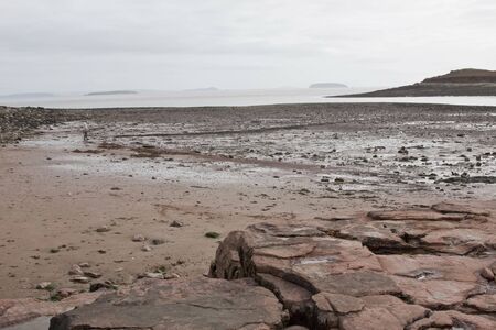 Islands in a hazy sky viewed from a beachの写真素材