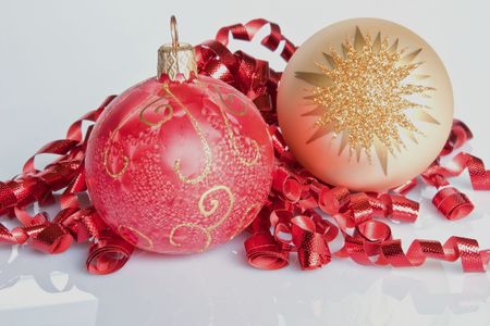 Two Christmas Baubles nestled in red curling ribbonの写真素材