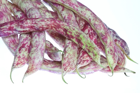 A selection on borlotti bean pods against a white background