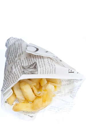 A portion of chips traditionally wrapped in newspaper & set against a white backgroundの写真素材