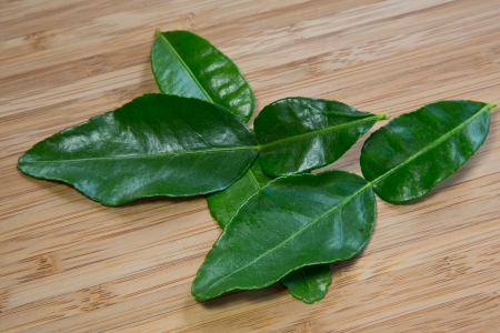 Fresh kaffir lime leaves on a bamboo boardの写真素材
