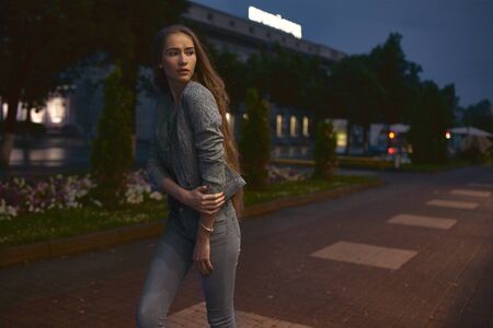 Girl in grey suit posing on the town streetの写真素材