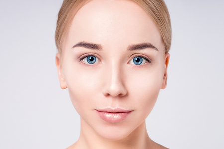 Woman beautiful face portrait. Beauty Portrait. Beautiful Spa model Girl with Perfect Fresh Clean Skin. Blonde female looking at camera. Youth and Skin Care Concept.の写真素材