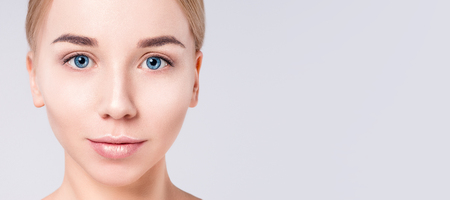 Woman beautiful face portrait. Beauty Portrait. Beautiful Spa model Girl with Perfect Fresh Clean Skin. Blonde female looking at camera. Youth and Skin Care Concept.の写真素材