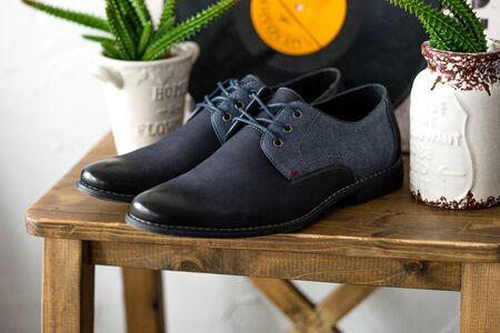 Men's dark blue shoes on wooden table. Fahion still-life boots. Classic accessory for a businessman.の写真素材