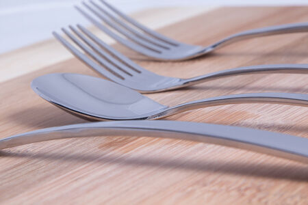 Cutlery on background bamboo board, spoon in focus の写真素材