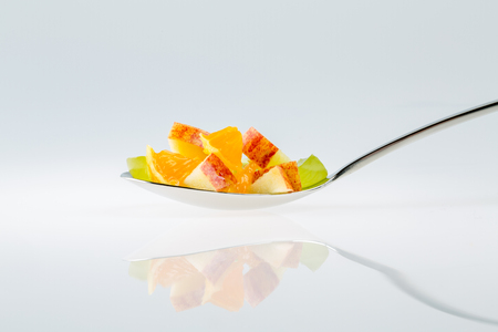fruit spoon on a glossy surfaceの写真素材