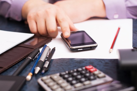 Businessman sitting at office desk and plans its workの写真素材