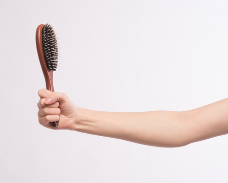 A hairbrush in a female handの写真素材