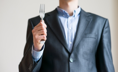 A man in a suit with a fork in his hand