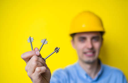 Builder in helmet hands keys to a new apartmentの写真素材