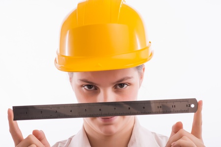 A young woman in a helmet with a ruler in hand