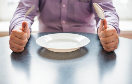 man with a spoon, a fork, a plateの写真素材