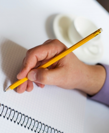 Businessman uses the phone and writes somethingの写真素材