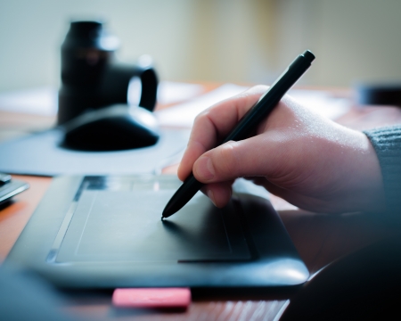Graphic designer using digital tablet and computer in the office