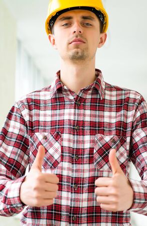engineer in a helmet holding thumb upの写真素材