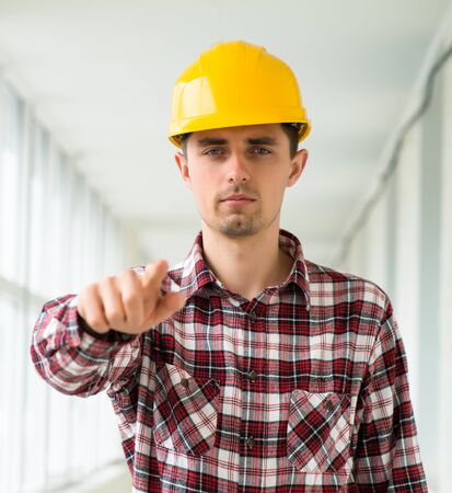 engineer in a helmet shows the index finger