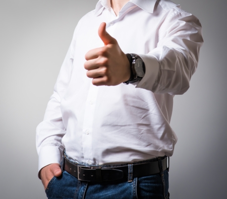 Successful cheering business man holding his thumb upの写真素材