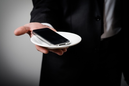 businessman holding a phone in his hand on a gray backgroundの写真素材