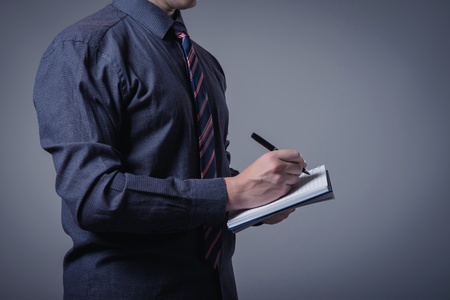 young builder in a building helmet with a notebook in handsの写真素材