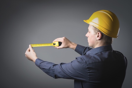 engineer in a helmet uses a tape measureの写真素材