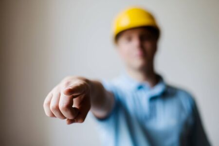 worker in a helmet shows the index fingerの写真素材
