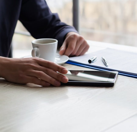 businessman using a tablet and drinking coffeeの写真素材