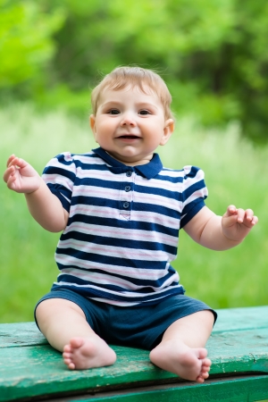 little boy sitting on a benchの写真素材