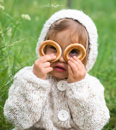 little girl looking through a bagelの写真素材
