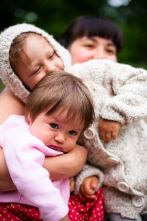 young mother with two daughters playing outdoors
