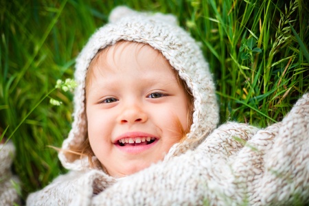 little girl lying on the grassの写真素材
