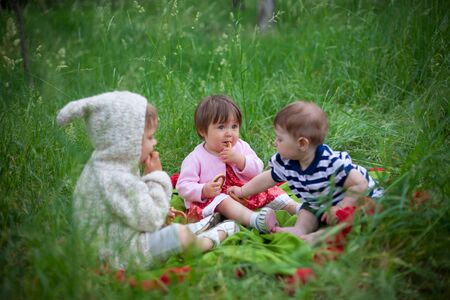 three small children play outdoorsの写真素材