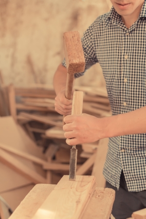 hand working in wood chisel carpenter tool hammerの写真素材