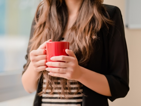young girl holding a cupの写真素材
