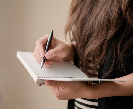 young woman writing in a notebookの写真素材