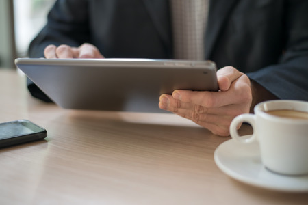 Businessman using digital tablet in cafe