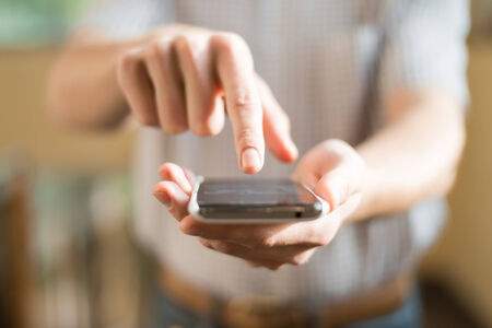 Human hand touches the screen a modern smartphoneの写真素材