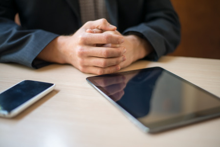 Man with tablet computer reading news at morning in cafeの写真素材