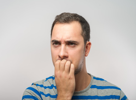 stressed mid adult businessman biting fingernailsの写真素材