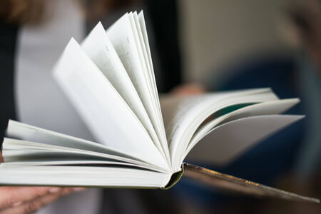 overhead view of hands holding a blank bookの写真素材