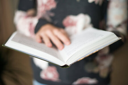 overhead view of hands holding a blank bookの写真素材